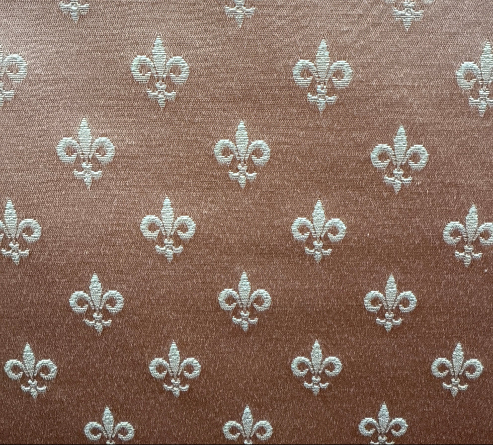 Pattern of fleur-de-lis symbols on a brown background