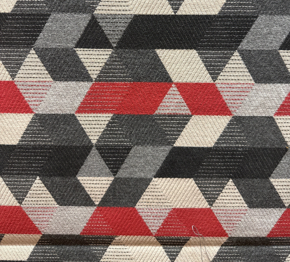 Geometric patterned fabric with red, black, and beige triangles.