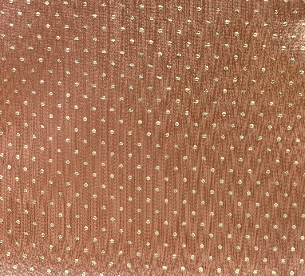 A close-up image of a pink fabric with a white polka dot pattern.