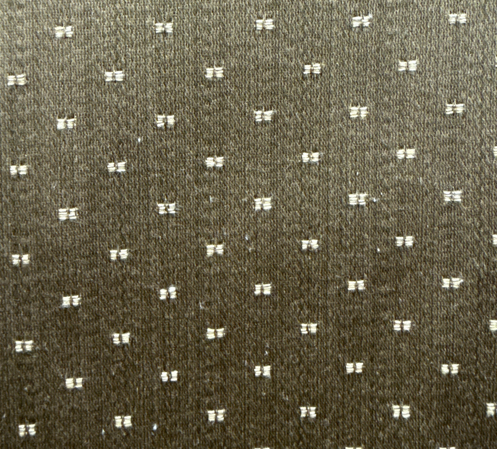 A close-up image of a textured fabric with a dotted pattern.