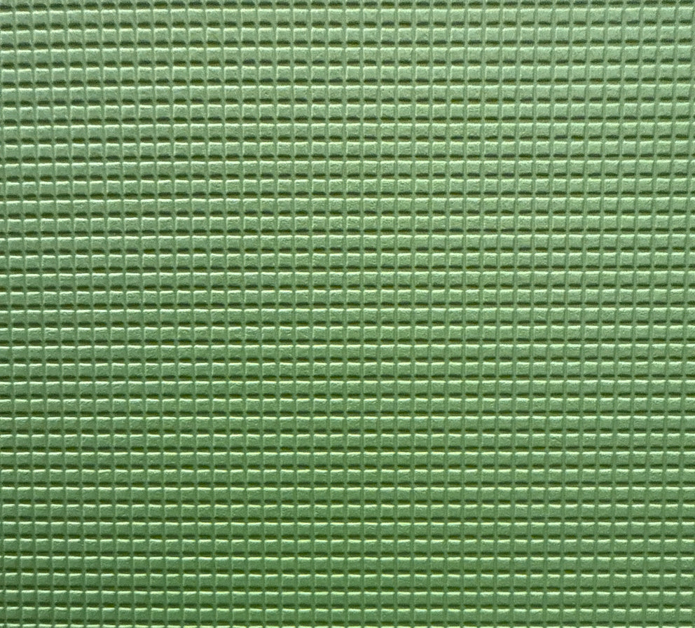 Close-up of a green, solid-colored vinyl upholstery fabric.
