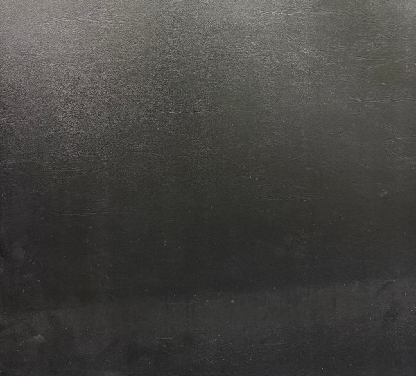 Close-up of a textured, solid black fabric with a visible grain.