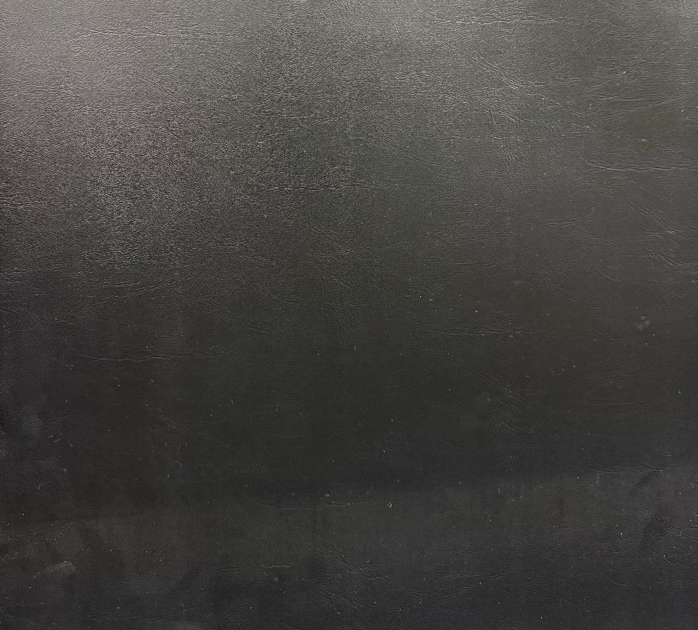 Close-up of a textured, solid black fabric with a visible grain.