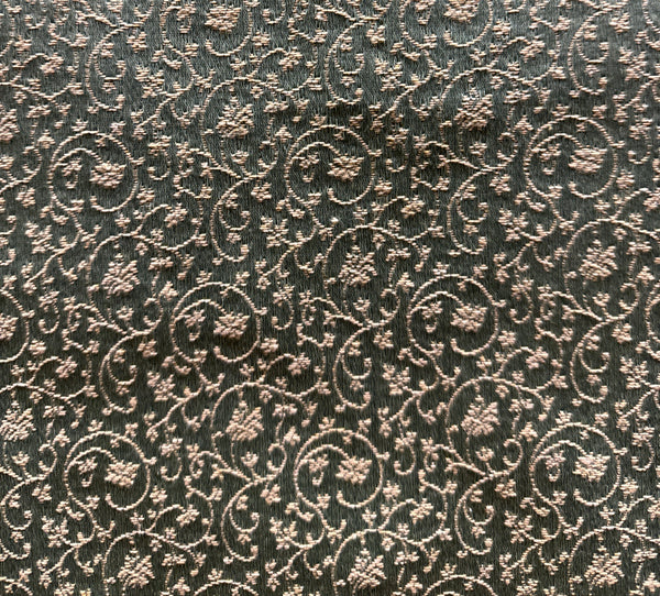 A close-up image of a patterned fabric with a floral design in a bronze color.