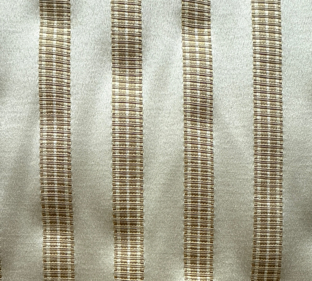 Close-up of a beige upholstery fabric with a striped pattern.