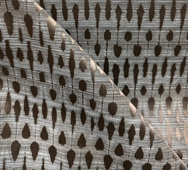 A fabric with a geometric pattern featuring overlapping geometric shapes in shades of gray and beige.