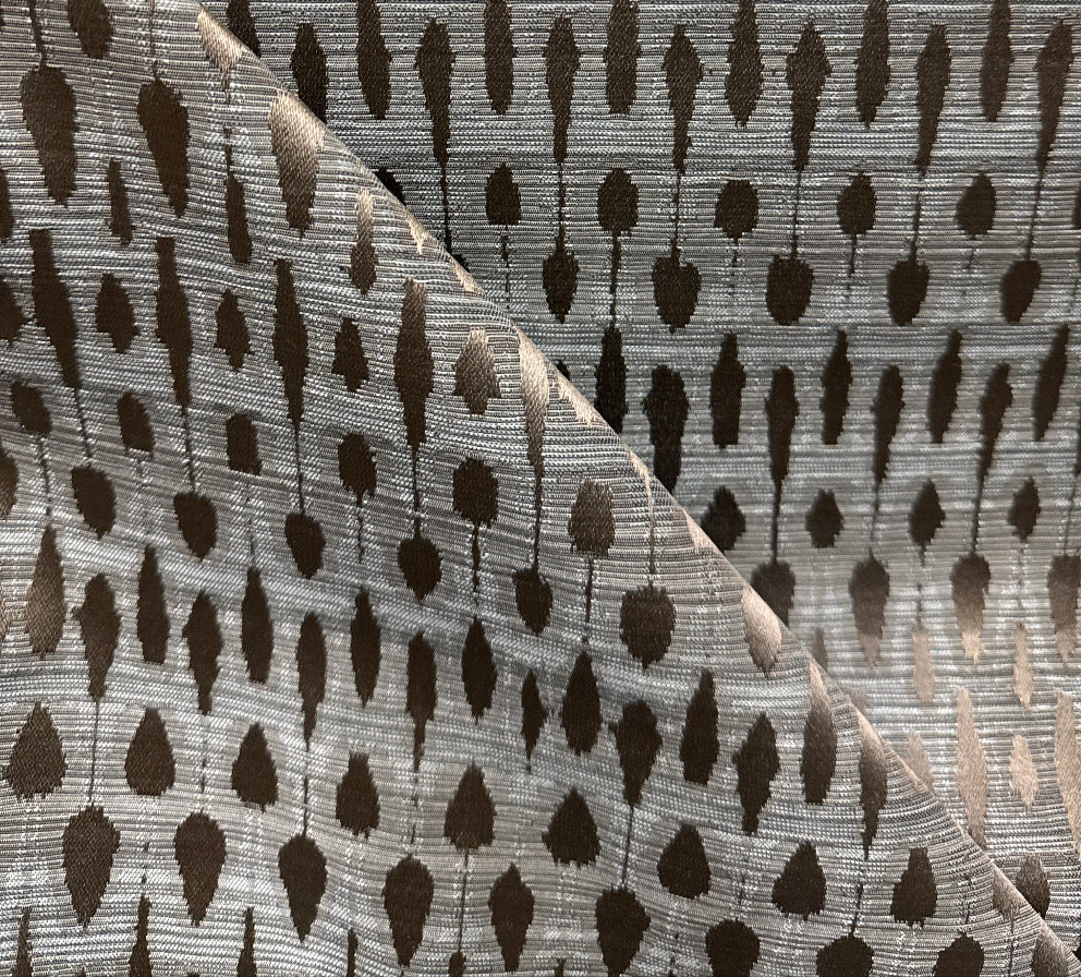 A fabric with a geometric pattern featuring overlapping geometric shapes in shades of gray and beige.