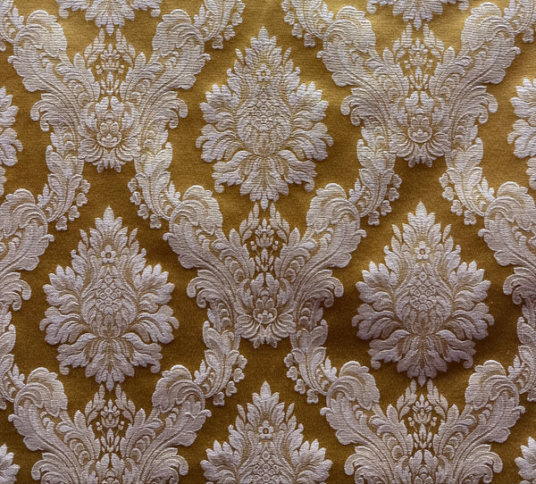 A close-up image of a golden yellow fabric with a white floral pattern.