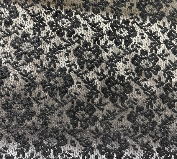 Close-up of a black lace fabric with a detailed pattern.