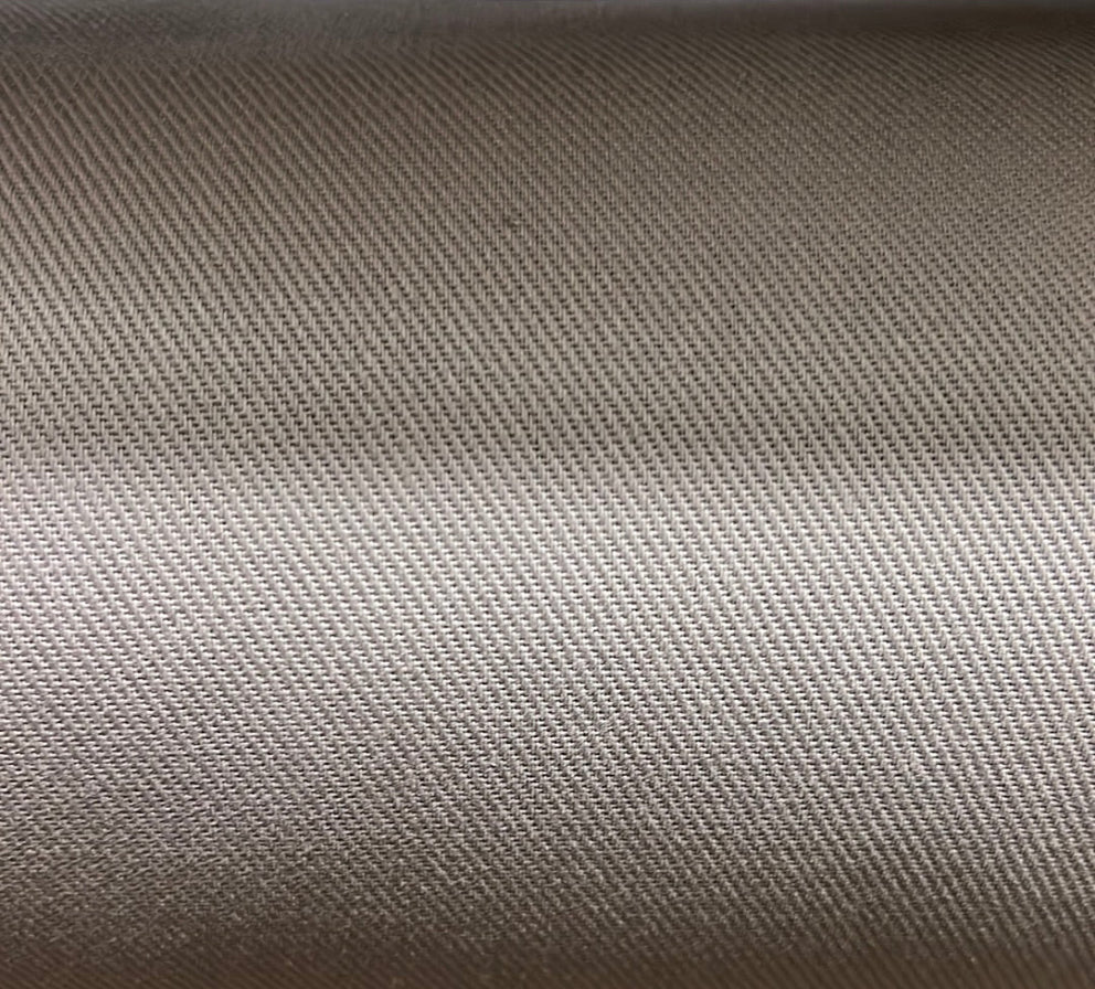 Close-up texture shot of a solid beige cotton fabric.