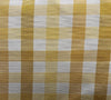 Close-up of a yellow and white checkered fabric, likely to be used for upholstery or drapery.