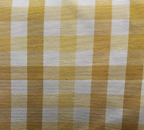 Close-up of a yellow and white checkered fabric, likely to be used for upholstery or drapery.